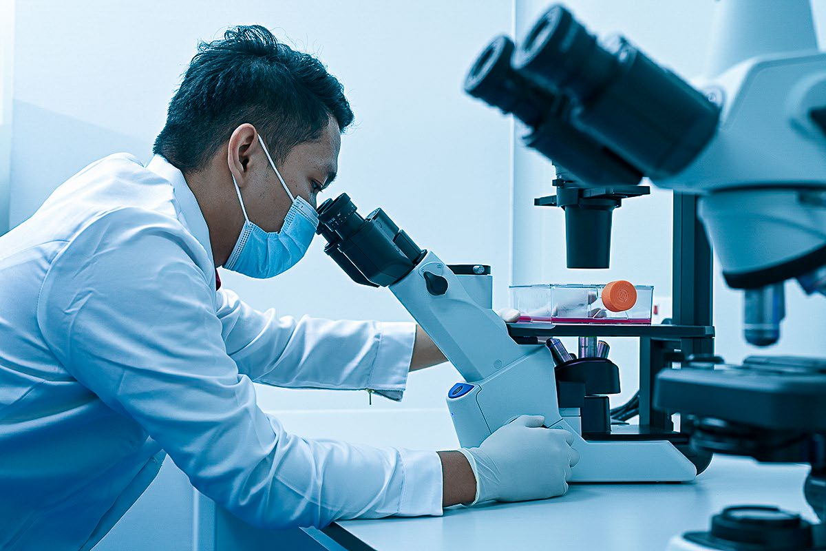 Scientist examining a sample under a microscope
